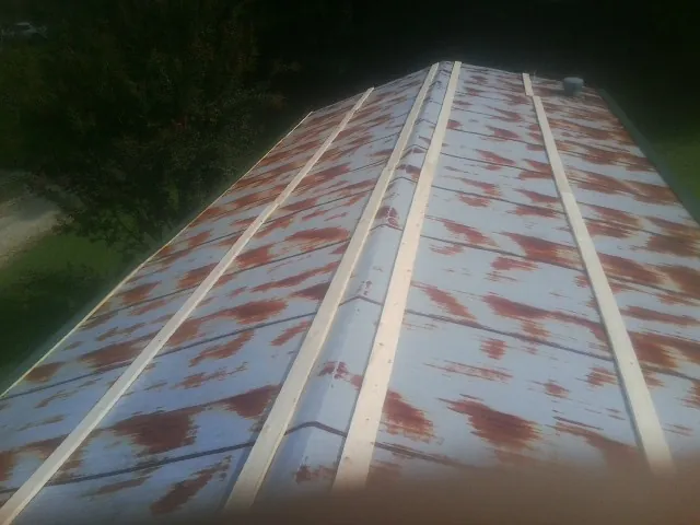 Rusted metal roof panels with new wood purlins before replacement — Storm Damage Roof Repair in Durham by Roofing Brothers